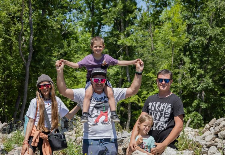 A joyful family enjoying a sunny day outdoors, captured in a lively and happy moment.