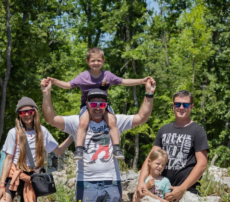 A joyful family enjoying a sunny day outdoors, captured in a lively and happy moment.