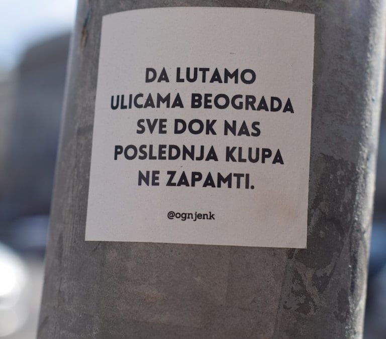 a sticker on a pole on a city street